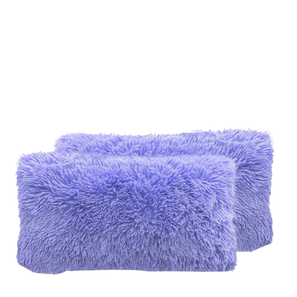 Set of two periwinkle faux fur throw pillows with fluffy texture on a light grey modern couch

