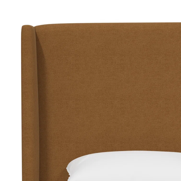 Amber king-size upholstered bed in linen fabric with wingback headboard and low-profile black metal legs.

