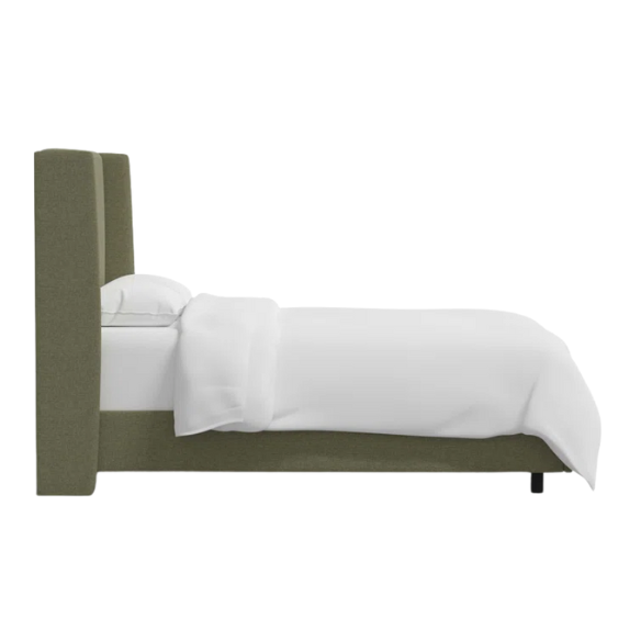 Avocado green king-size upholstered bed in linen fabric with wingback headboard and low-profile black metal legs.

