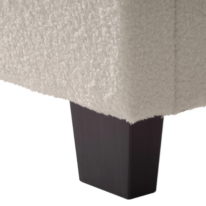 Beige full-size upholstered bed with a high rectangular bouclé headboard, cushioned frame, and clean modern lines, shown in a neutral-toned bedroom.

