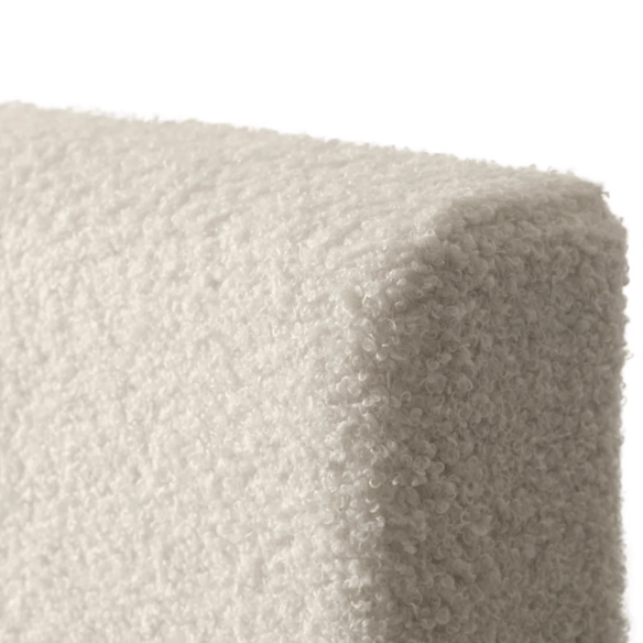 Beige full-size upholstered bed with a high rectangular bouclé headboard, cushioned frame, and clean modern lines, shown in a neutral-toned bedroom.

