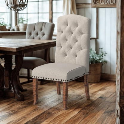 Set of 2 beige button-tufted farmhouse dining chairs with rustic wood legs, nailhead trim, and upholstered linen-like fabric.

