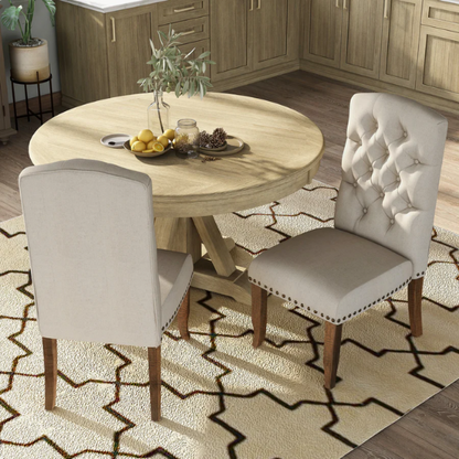 Set of 2 beige button-tufted farmhouse dining chairs with rustic wood legs, nailhead trim, and upholstered linen-like fabric.

