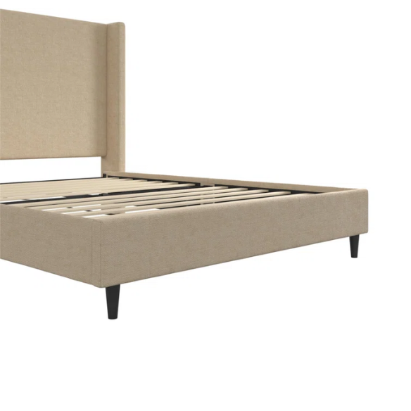 Beige canvas queen bed with tall wingback headboard and black conical legs, styled in a modern bedroom setting.

