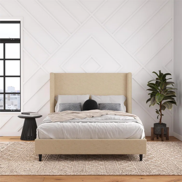 Beige canvas queen bed with tall wingback headboard and black conical legs, styled in a modern bedroom setting.

