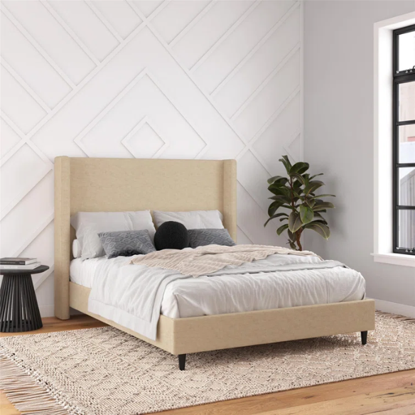 Beige canvas queen bed with tall wingback headboard and black conical legs, styled in a modern bedroom setting.

