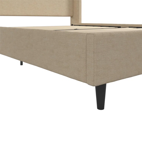 Beige canvas queen bed with tall wingback headboard and black conical legs, styled in a modern bedroom setting.

