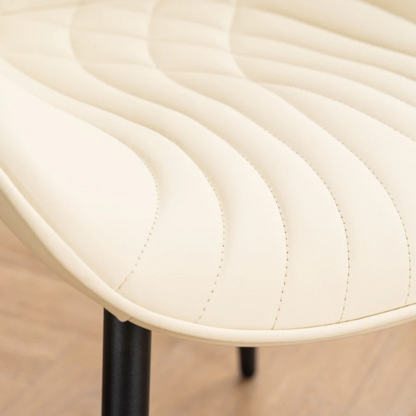Set of 2 beige faux leather dining chairs with modern fishtail backrest and black metal legs, designed for contemporary dining spaces.

