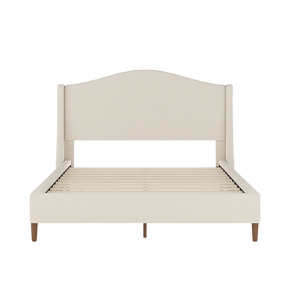 Full-size beige upholstered platform bed with curved wingback headboard, cushioned side rails, and tapered wooden legs, shown in a modern bedroom setting.

