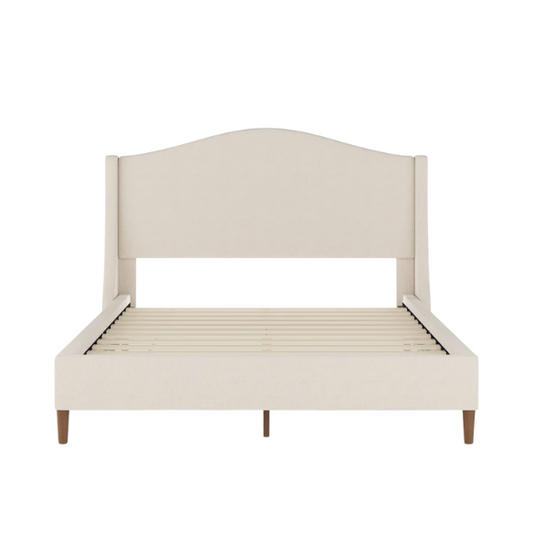 Full-size beige upholstered platform bed with curved wingback headboard, cushioned side rails, and tapered wooden legs, shown in a modern bedroom setting.

