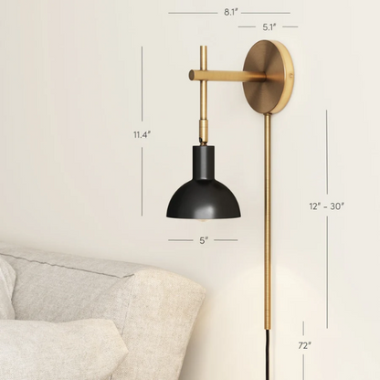 Black and brass plug-in wall sconce with adjustable swing arm and bell-shaped brass shade, featuring built-in switch and cord cover for bedside or reading nook lighting


