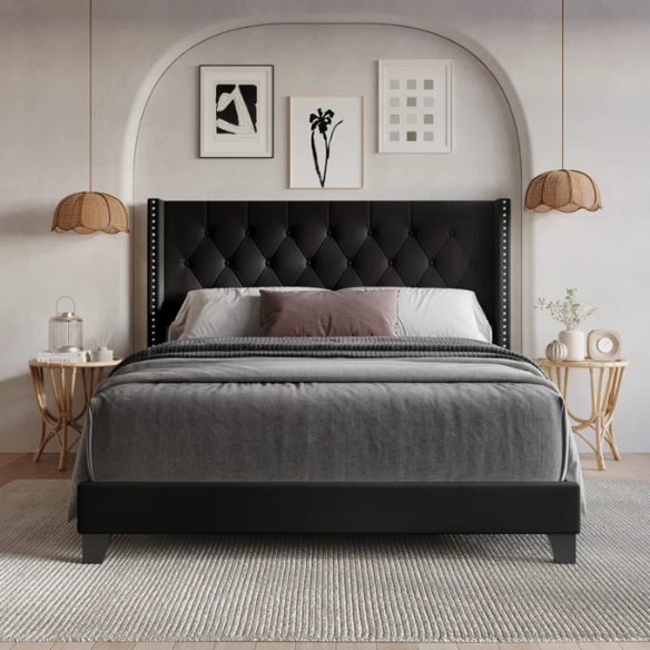Black queen-size bed with faux leather upholstery, tufted wingback headboard, nailhead trim, and low-profile wood frame.

