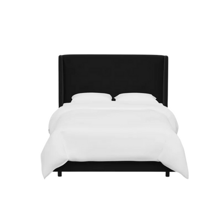 Black king-size upholstered bed with velvet fabric, wingback headboard, and low-profile black metal legs.

