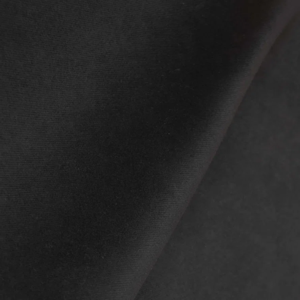 Black king-size upholstered bed with velvet fabric, wingback headboard, and low-profile black metal legs.

