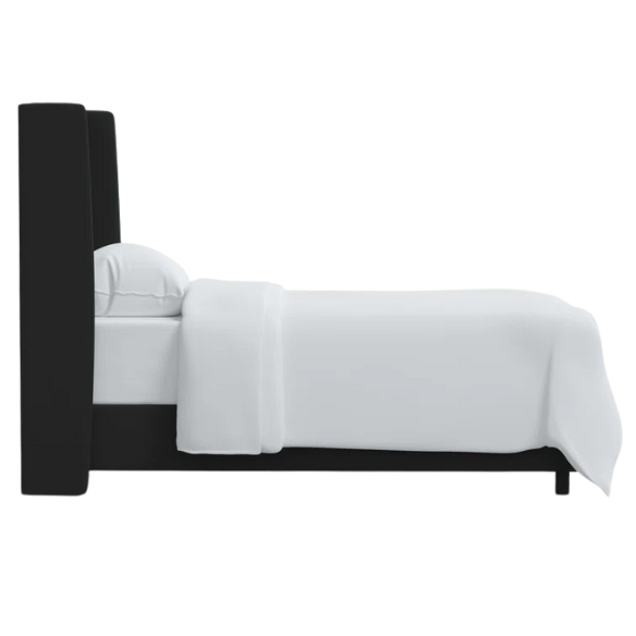 Black king-size upholstered bed with velvet fabric, wingback headboard, and low-profile black metal legs.

