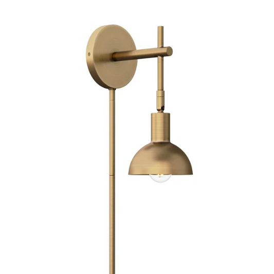 Brass plug-in wall sconce with adjustable swing arm and bell shade, featuring a built-in switch and cord cover for modern bedroom or reading nook lighting

