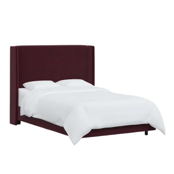 Burgundy king-size upholstered bed in velvet fabric with wingback headboard and low-profile black metal legs.


