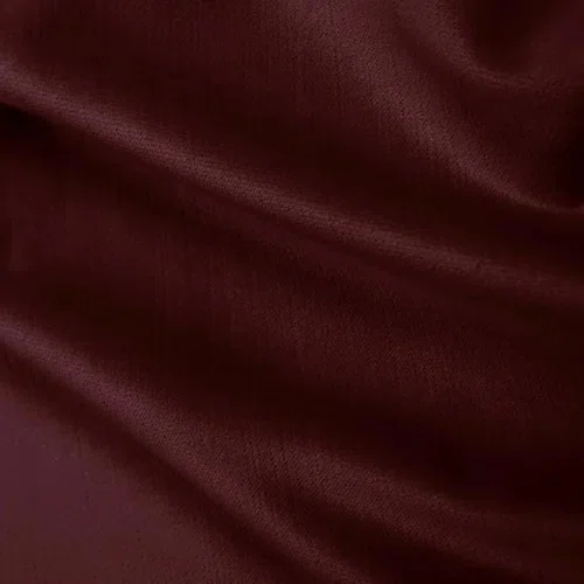 Burgundy king-size upholstered bed in velvet fabric with wingback headboard and low-profile black metal legs.

