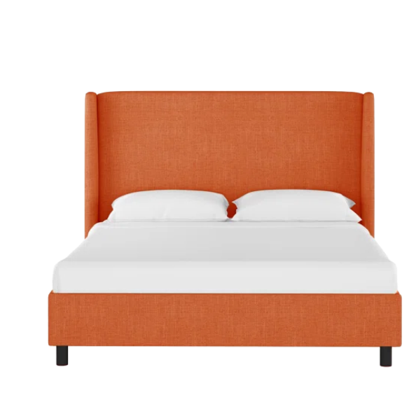 Burnt orange king-size upholstered bed in linen fabric with wingback headboard and black metal legs.

