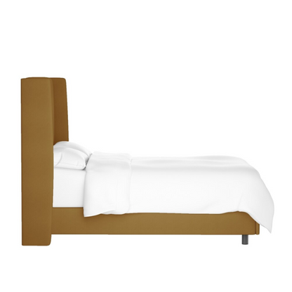 Camel king-size upholstered bed in velvet fabric with wingback headboard and low-profile black metal legs.

