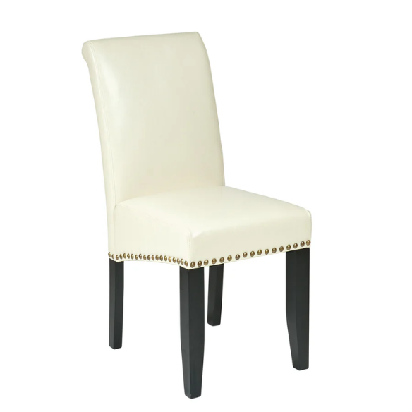 Cream faux leather Parsons chair with scrolled high back, antique bronze nailhead trim, and solid wood legs