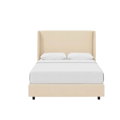 Cream king-size upholstered bed in velvet fabric with wingback headboard and low-profile black metal legs.

