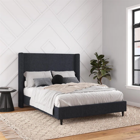 Dark blue canvas queen-size platform bed with tall wingback headboard and black tapered legs.

