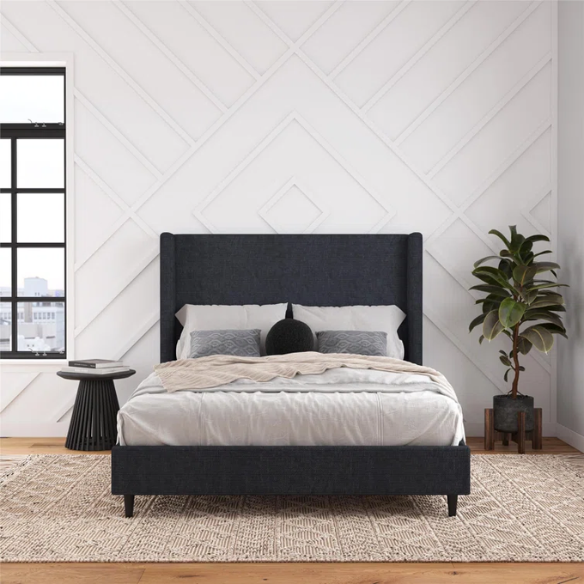 Dark blue canvas queen-size platform bed with tall wingback headboard and black tapered legs.

