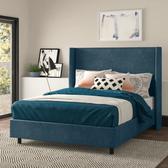 Dark blue king-size upholstered bed in linen fabric with wingback headboard and black metal legs.

