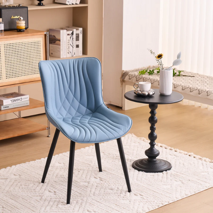 Set of 2 dusty blue faux leather dining chairs with fishtail tufted back and black metal legs, perfect for modern dining rooms or kitchen spaces.


