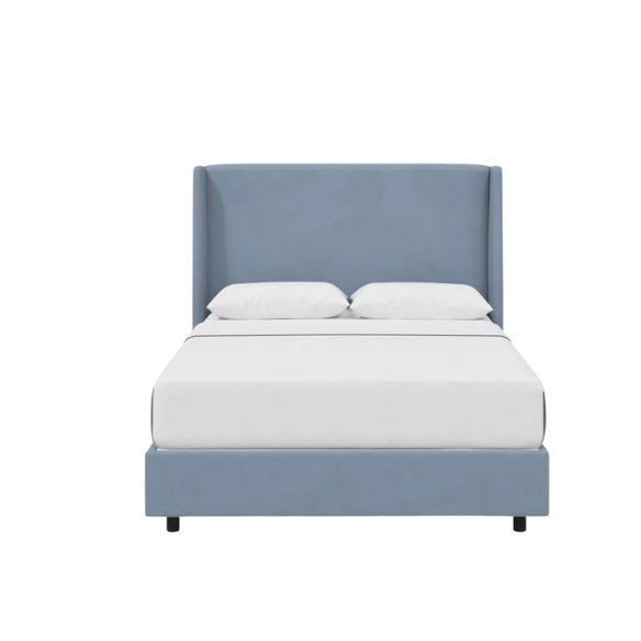 Dusty blue king-size upholstered bed in linen fabric with wingback headboard and low-profile black metal legs.

