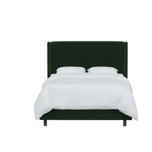 Emerald green king-size upholstered bed in velvet fabric with wingback headboard and low-profile black metal legs.

