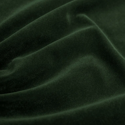 Emerald green king-size upholstered bed in velvet fabric with wingback headboard and low-profile black metal legs.

