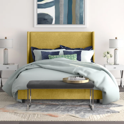 Golden yellow king-size upholstered bed in linen fabric with wingback headboard and black metal legs.

