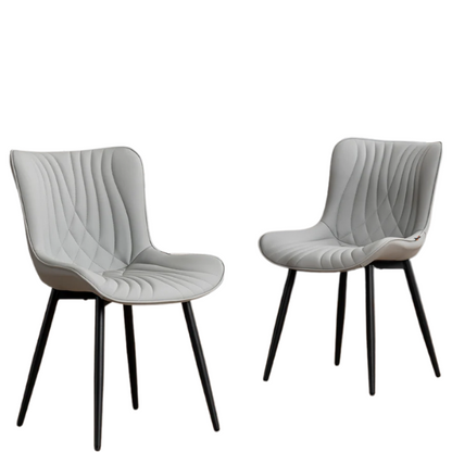 Set of 2 grey faux leather dining chairs with fishtail tufted backs and black metal legs, ideal for modern and minimalist dining room interiors.

