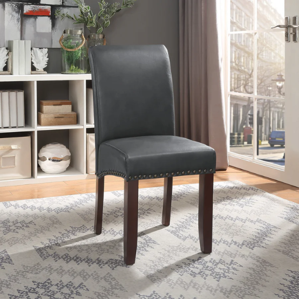 Grey leather Parsons chair with high back, scrolled shoulders, antique bronze nailhead trim, and solid wood legs