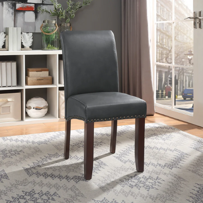 Grey leather Parsons chair with high back, scrolled shoulders, antique bronze nailhead trim, and solid wood legs