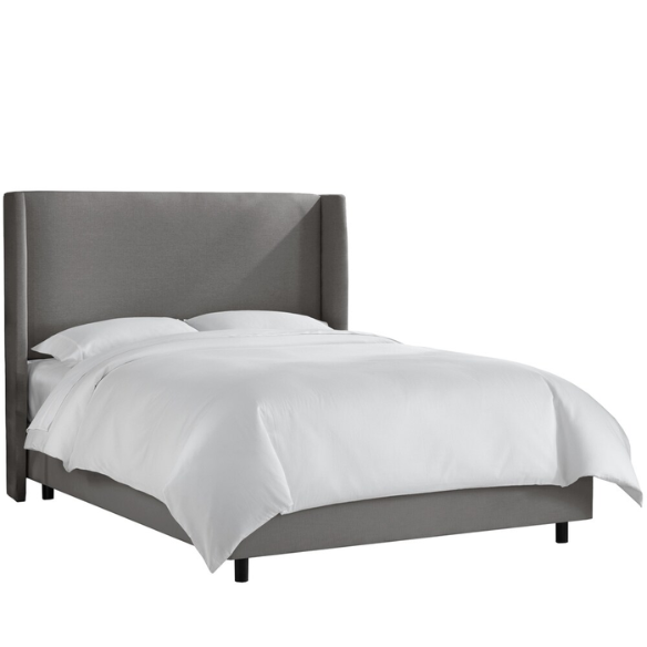 Grey king-size upholstered bed in linen fabric with wingback headboard and black metal legs.

