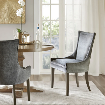 Set of 2 upholstered armless dining chairs in soft grey chenille with high backs, piped detailing, and solid wood legs.

