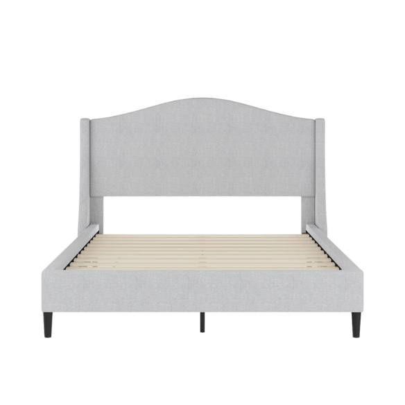 Full-size grey upholstered platform bed with curved wingback headboard, cushioned side rails, and tapered wooden legs in a stylish modern bedroom.

