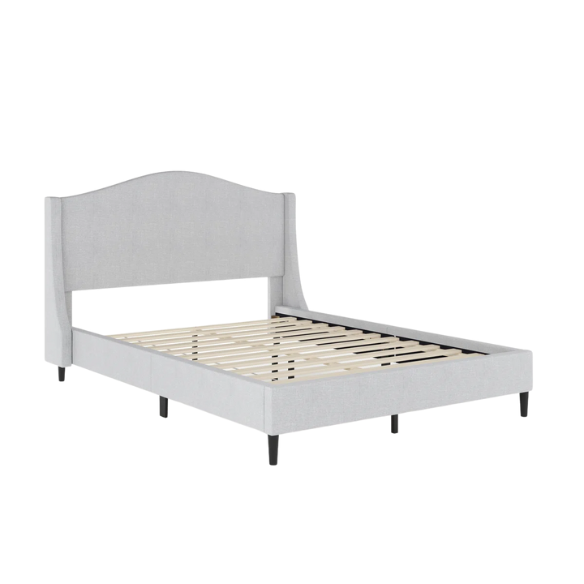 Full-size grey upholstered platform bed with curved wingback headboard, cushioned side rails, and tapered wooden legs in a stylish modern bedroom.

