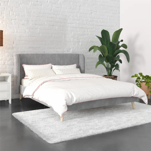 Grey velvet upholstered queen-size platform bed with wingback tufted headboard and mid-century wooden legs.

