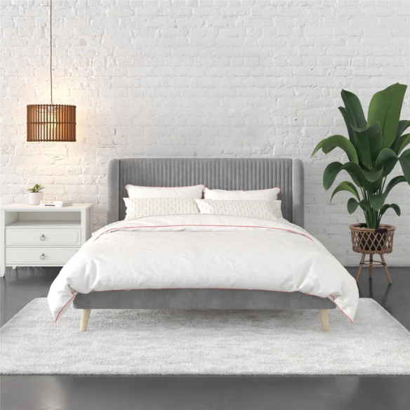 Grey velvet upholstered queen-size platform bed with wingback tufted headboard and mid-century wooden legs.

