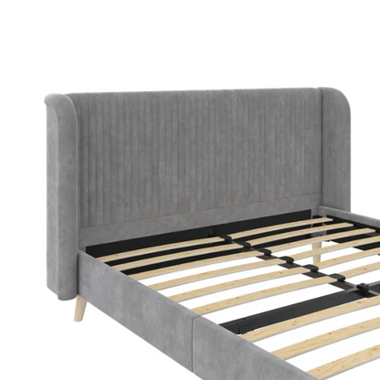 Grey velvet upholstered queen-size platform bed with wingback tufted headboard and mid-century wooden legs.

