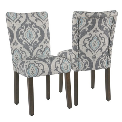 Set of two Parsons dining chairs with grey, white, and light blue floral upholstery, high back design, scalloped seat front, and wood legs