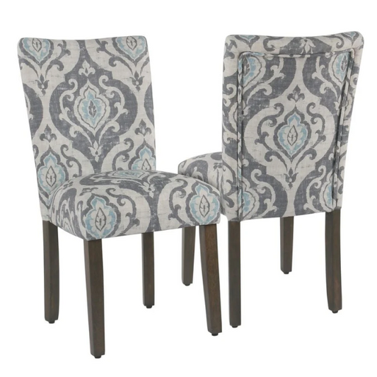 Set of two Parsons dining chairs with grey, white, and light blue floral upholstery, high back design, scalloped seat front, and wood legs
