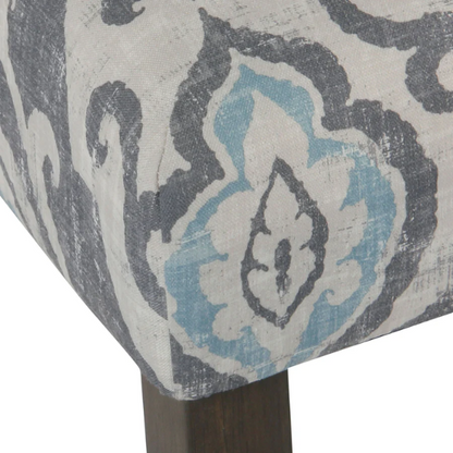 Set of two Parsons dining chairs with grey, white, and light blue floral upholstery, high back design, scalloped seat front, and wood legs