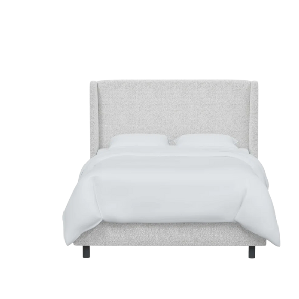 Ivory king-size upholstered bed in bouclé fabric with wingback headboard and low-profile black metal legs.


