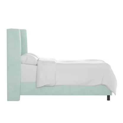 Light aqua king-size upholstered bed in velvet fabric with wingback headboard and low-profile black metal legs.

