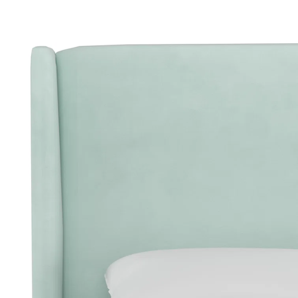 Light aqua king-size upholstered bed in velvet fabric with wingback headboard and low-profile black metal legs.

